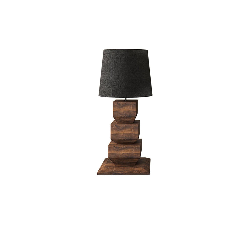 Tall table lamp with a black drum shade on stacked wood blocks, plain background