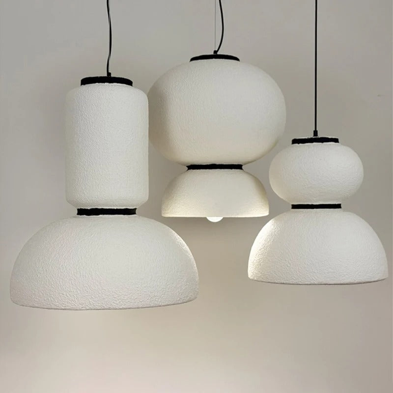 Three textured white pendants hung at staggered heights