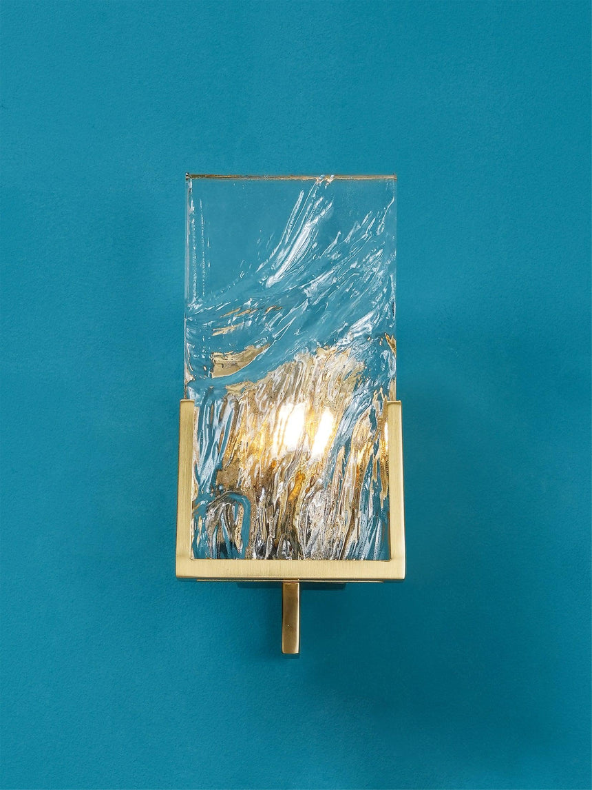 The brass frame and glass panel on a teal wall
