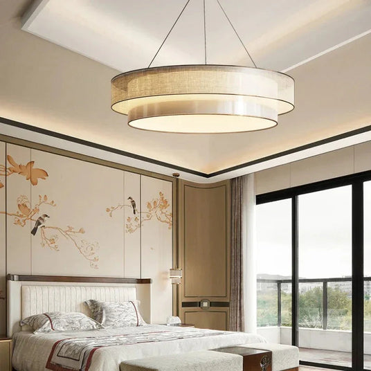 Tiered drum pendant light hung over a bed in a panelled bedroom
