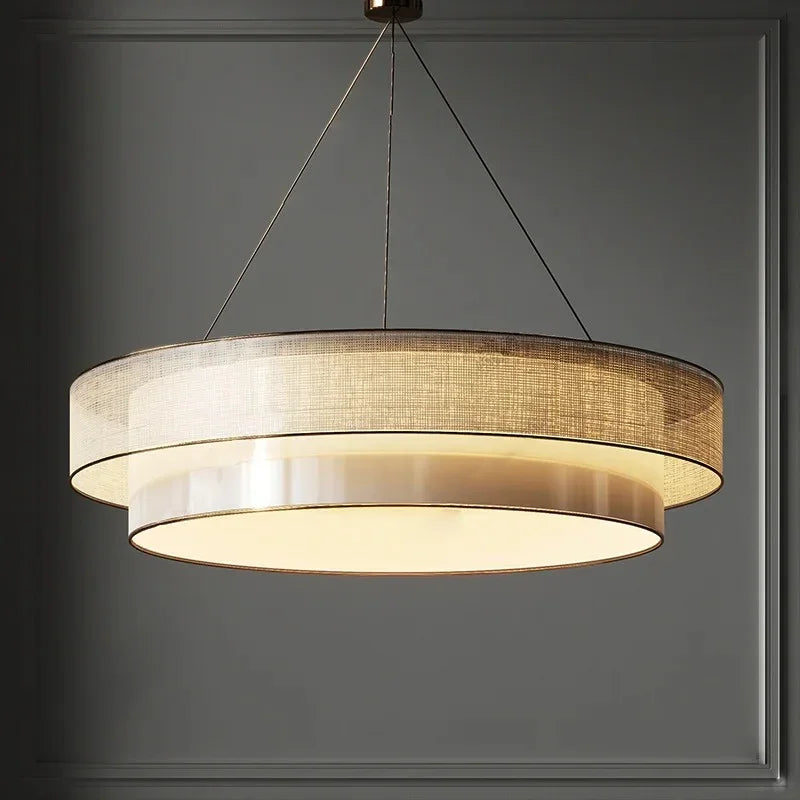 Tiered drum pendant light seen from below against a dark wall