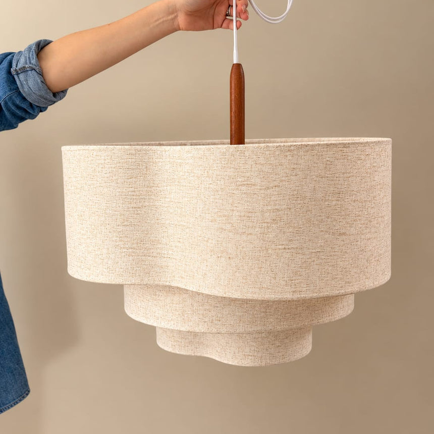 Two tier drum shade held up against a pale wall