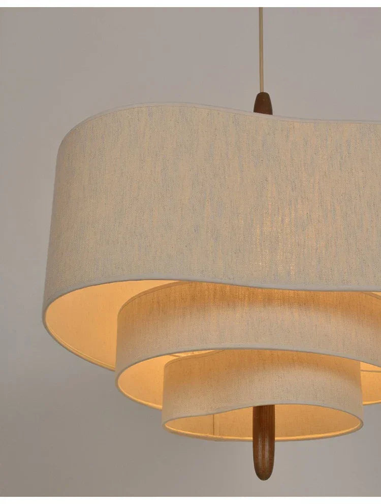 Two tier drum shade lit on a plain background