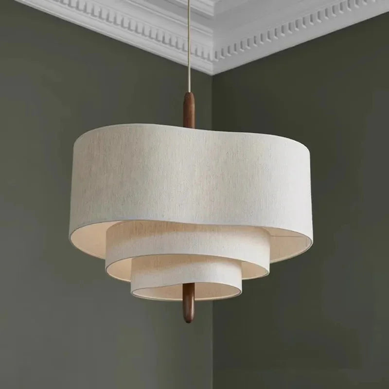 Tiered drum pendant light hung in a corner with green walls
