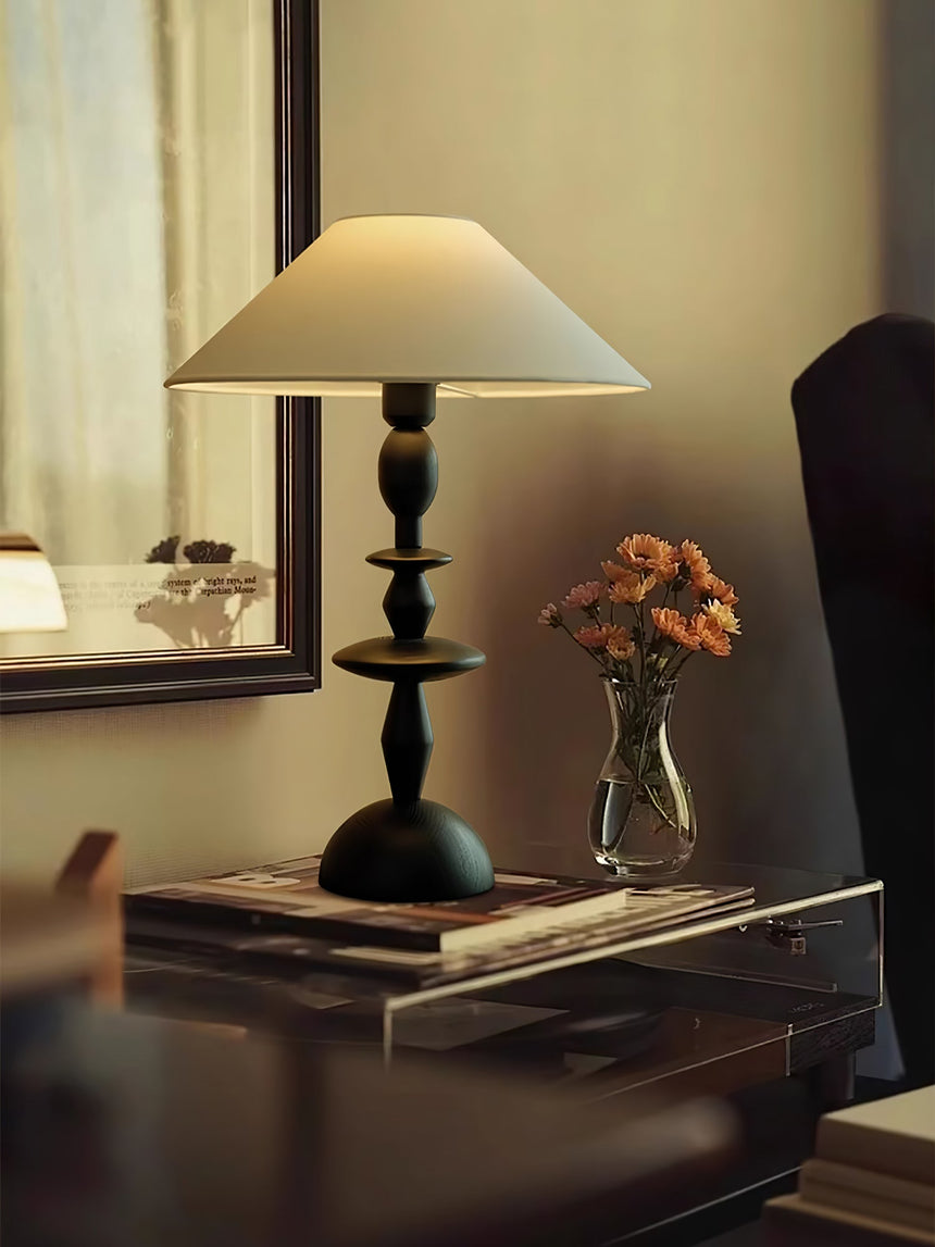 Turned spindle table lamp seen from an angle, the disc turnings visible