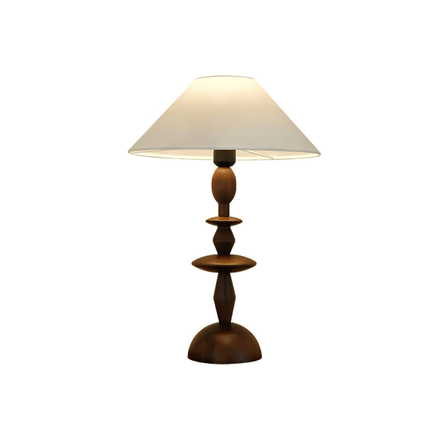 Turned spindle table lamp in a walnut tone against a plain white ground