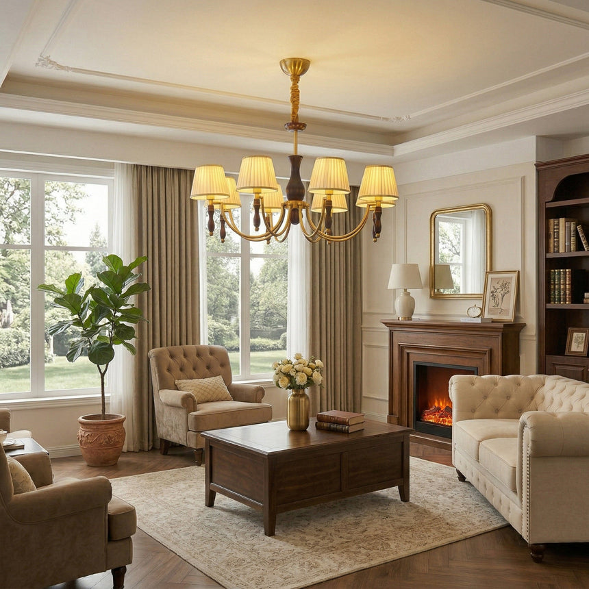 Chandelier lit in a living room above a sofa beside a fireplace