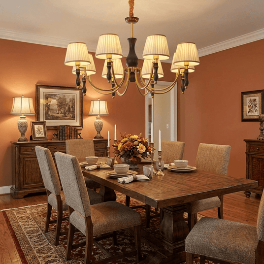The fitting lit in a dining room with deep red walls and a sideboard
