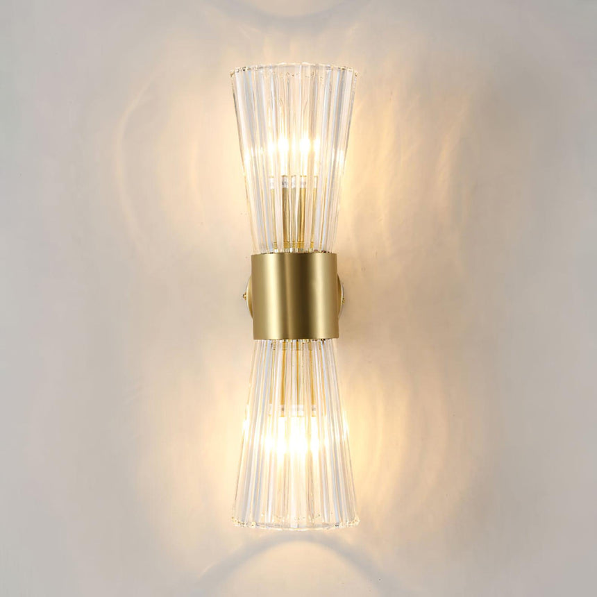 The sconce lit warm, light passing up and down through the ribbed glass