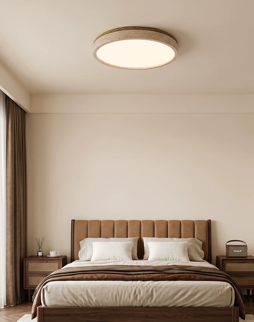 Round travertine ceiling light above a walnut bed with two matching nightstands