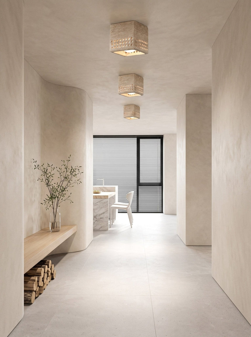 Square travertine block ceiling light in a plaster hallway leading to a dining area