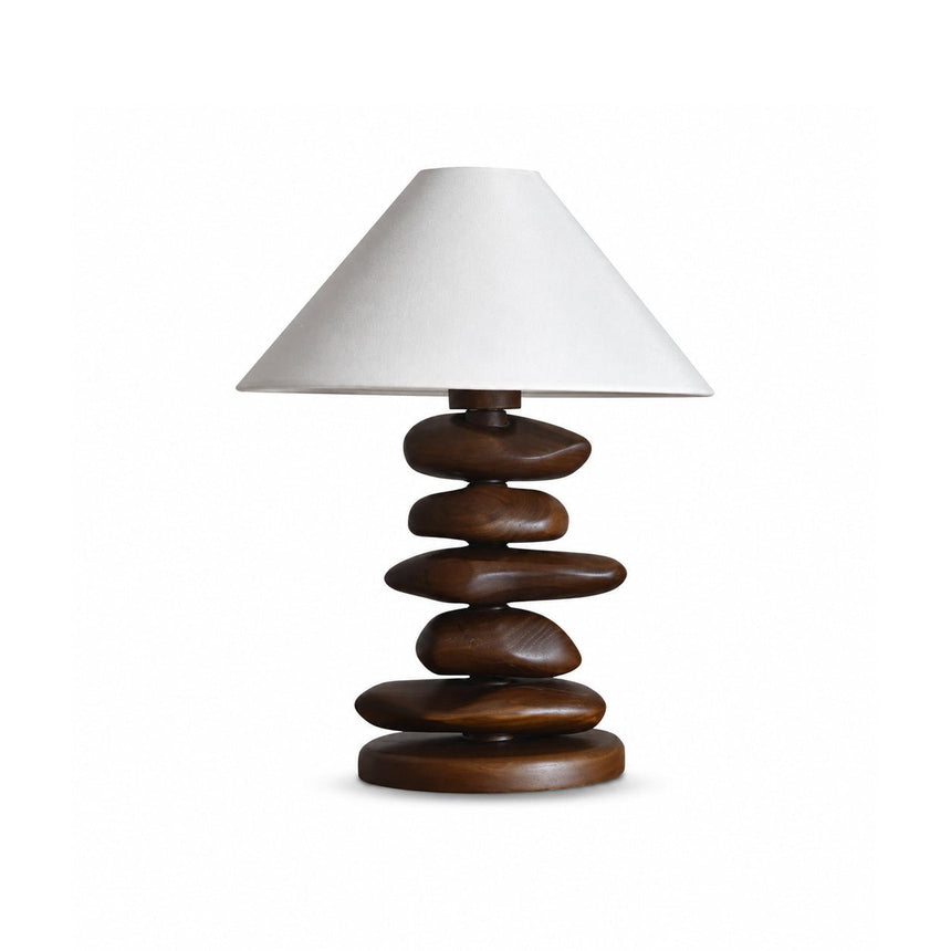 Unique table lamp with a dark wood pebble stack on a plain ground