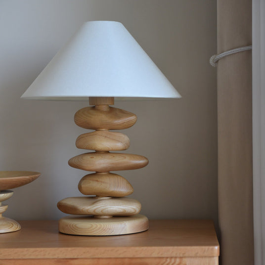Close view of a light wood pebble stack under the cream shade