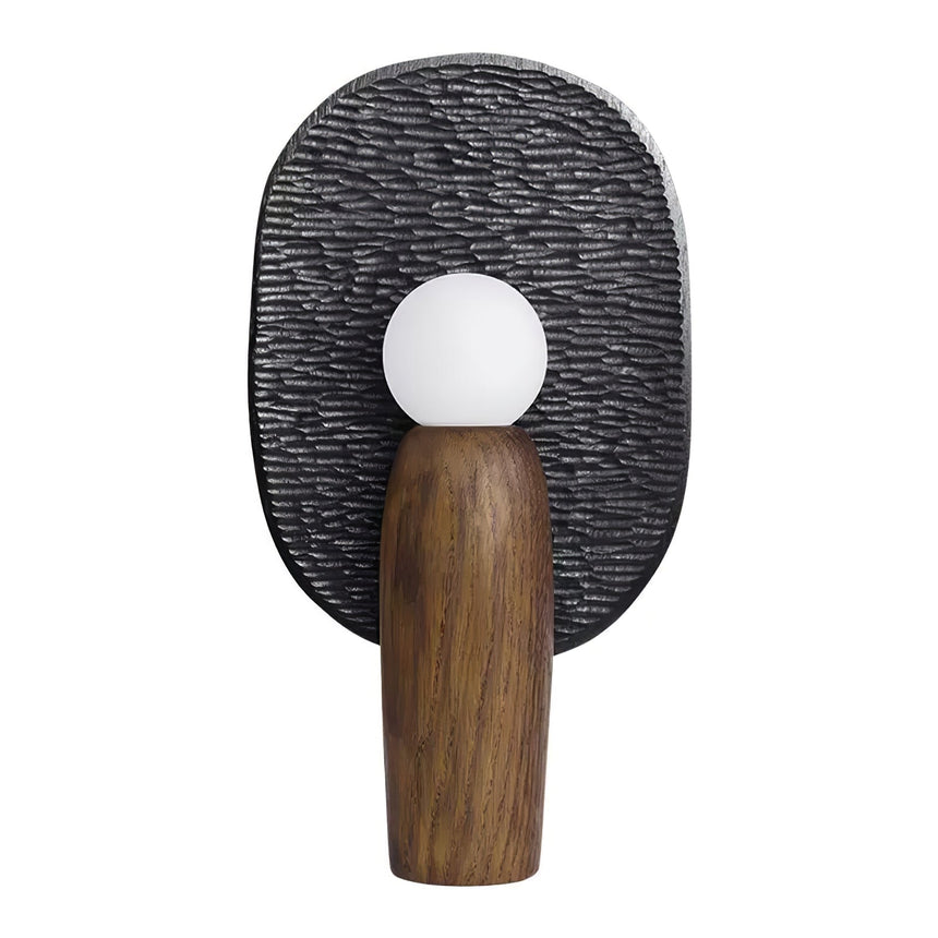 Charcoal backplate table lamp lit, the opal globe glowing against the texture