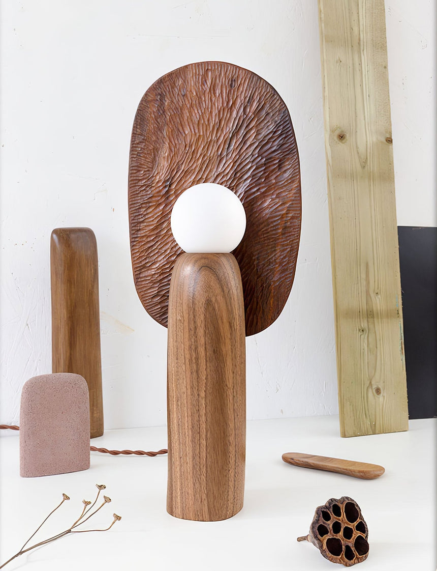 Bronze backplate table lamp in a studio setting beside raw wood offcuts