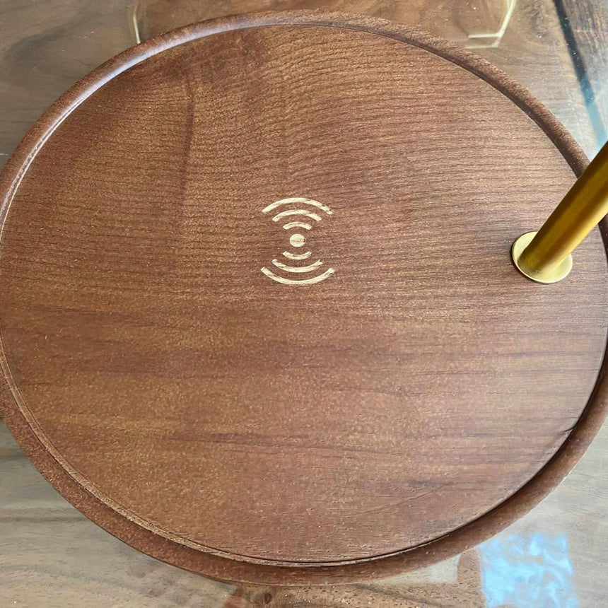 Angled close view of the walnut base showing the charging symbol and pole