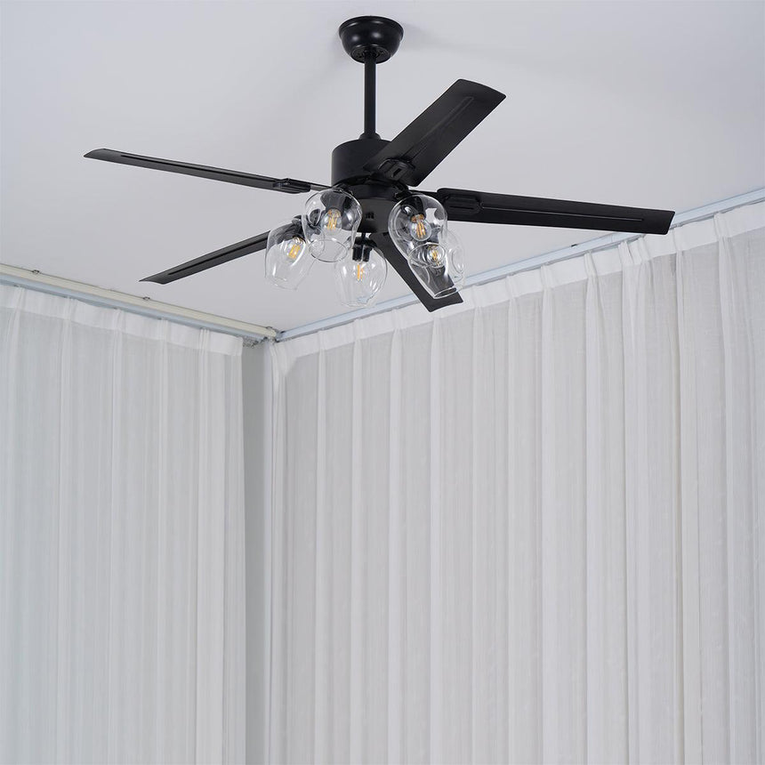 Black ceiling fan in a corner of a room with white curtains