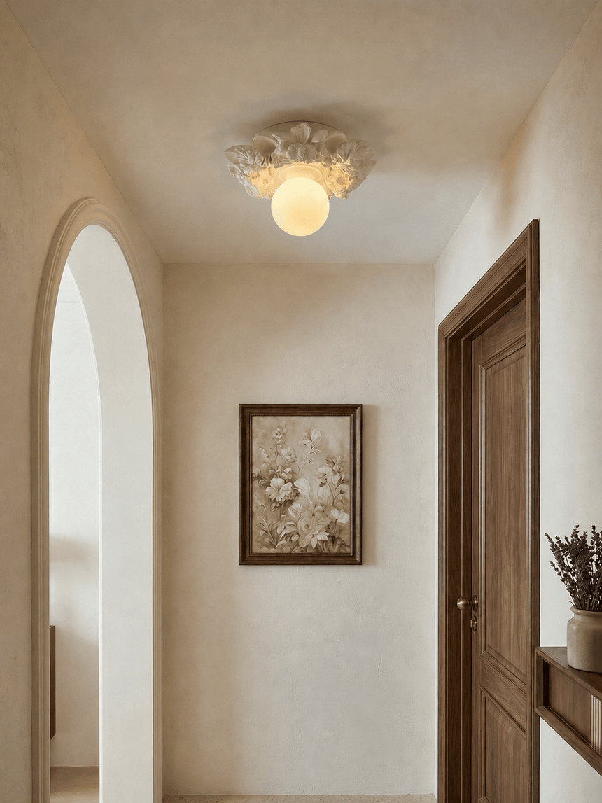 Carved floral ceiling light in a plaster hallway with a wood door