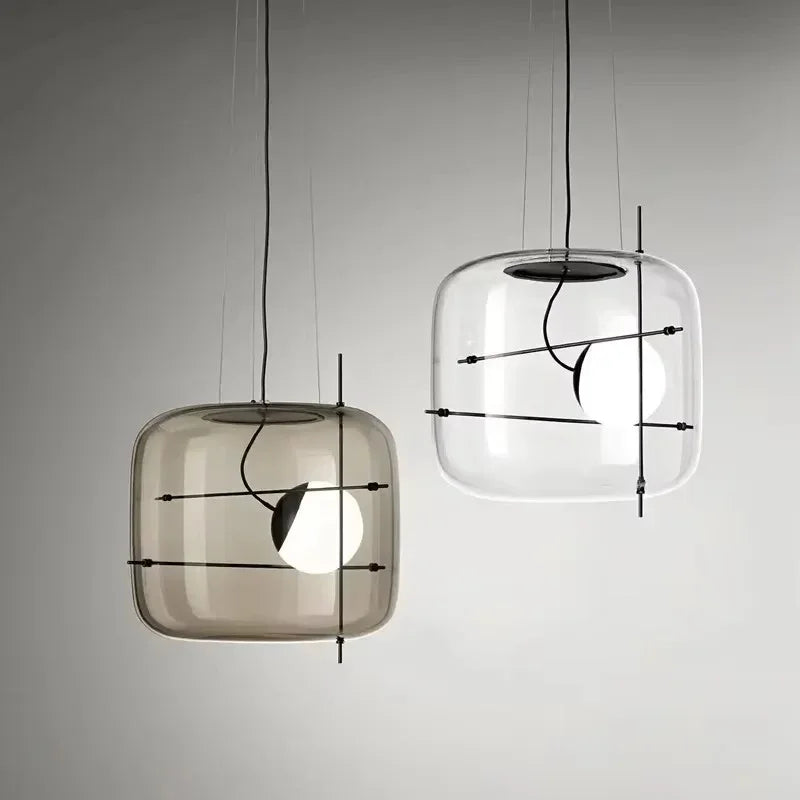 Two drum pendants in different tints lit side by side on a pale wall