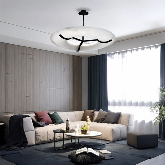 The lit ring in a living room with a sofa, low tables and a tall window