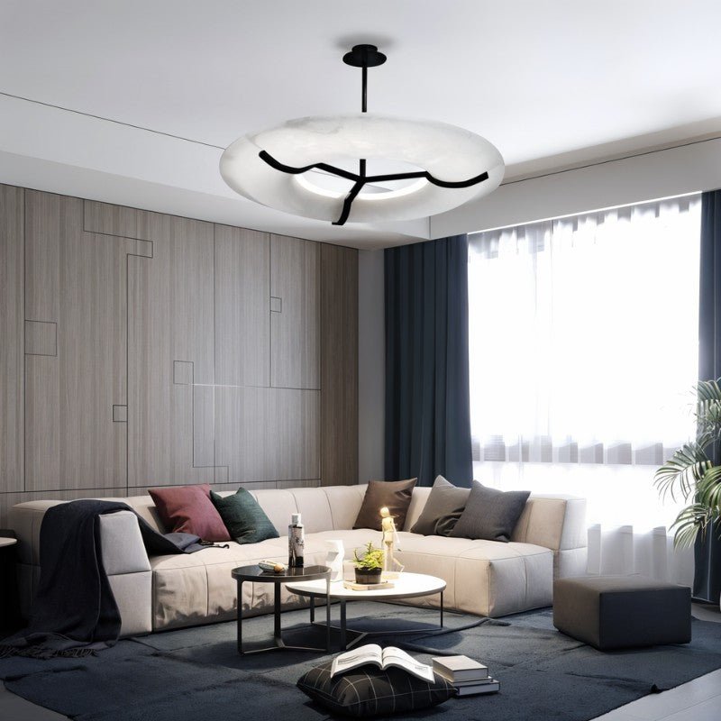The lit ring in a living room with a sofa, low tables and a tall window