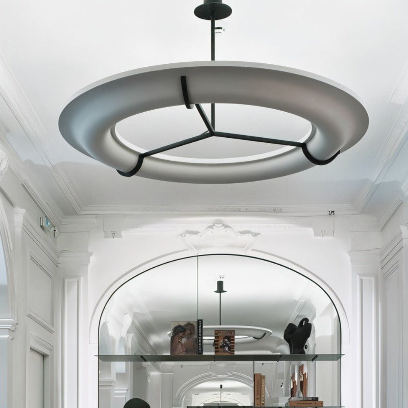 The lit ring in a white hall under an arch with shelves along the wall