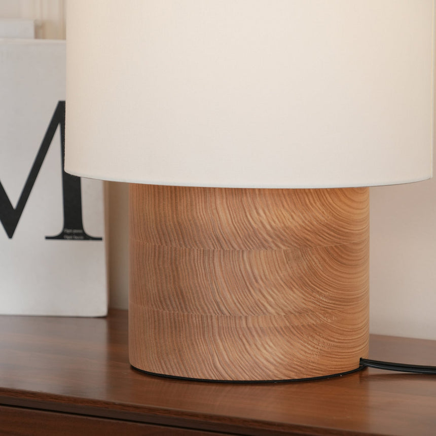 Close view of the brushed wood plinth under the cloth shade