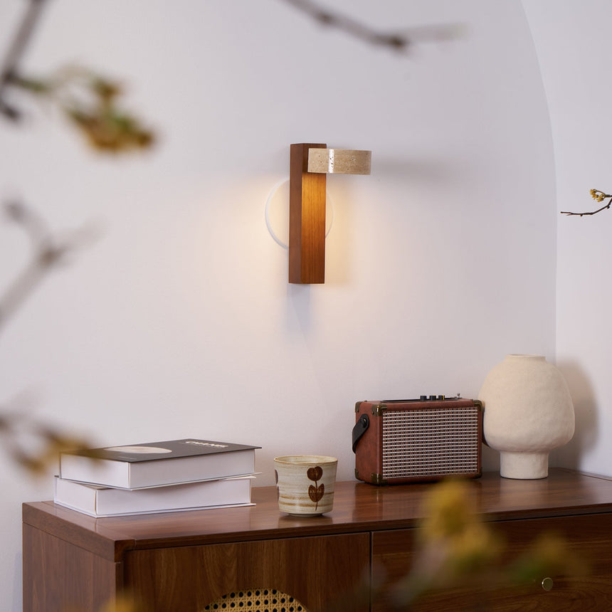 Lamp lit in a plaster alcove above a sideboard with books and a ceramic cup