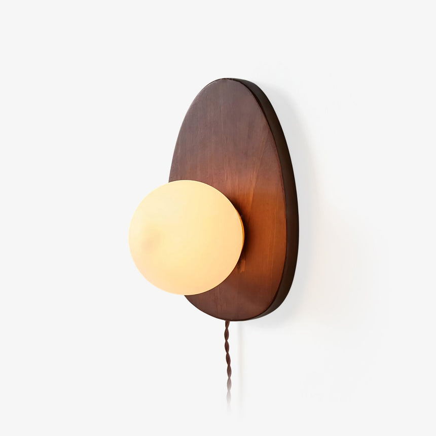 Oval walnut backplate with a white glass sphere set into its lower edge