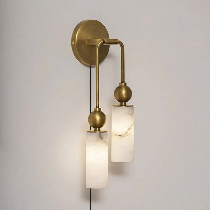 The brass version with two lit stone tubes, seen on a pale wall