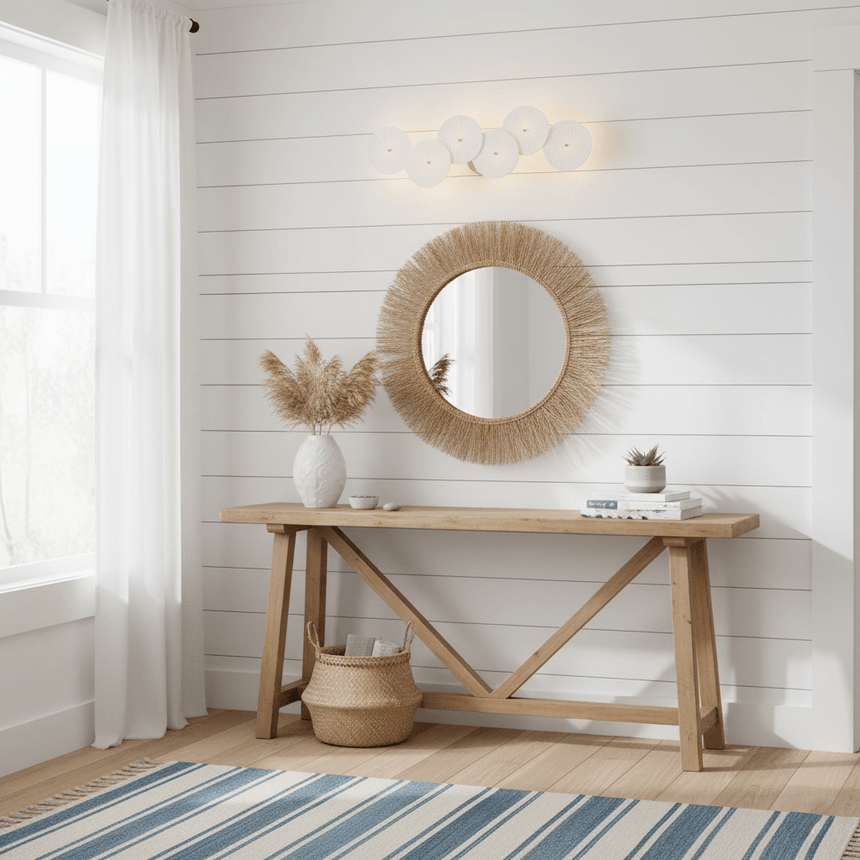 The disc light above a wood console table with a round woven mirror
