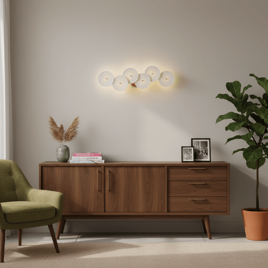 The disc light above a walnut sideboard and a green armchair