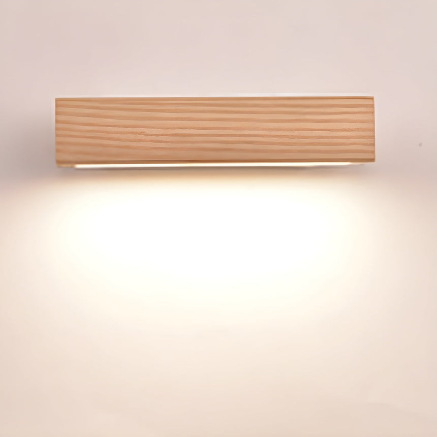 The wood bar lit level on its bracket, a broad wash falling down the wall