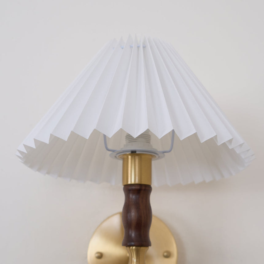 Pleated shade and walnut column seen unlit against a plain background