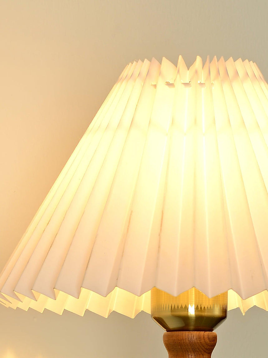 Close view of the pleated fabric shade lit from inside, folds catching light