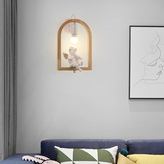 Sconce lit above a navy sofa with cushions beside a framed line drawing