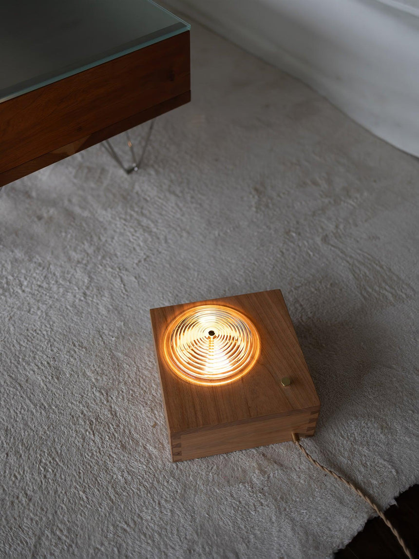 Wood box lit standing on a pale rug, showing it works off the wall too