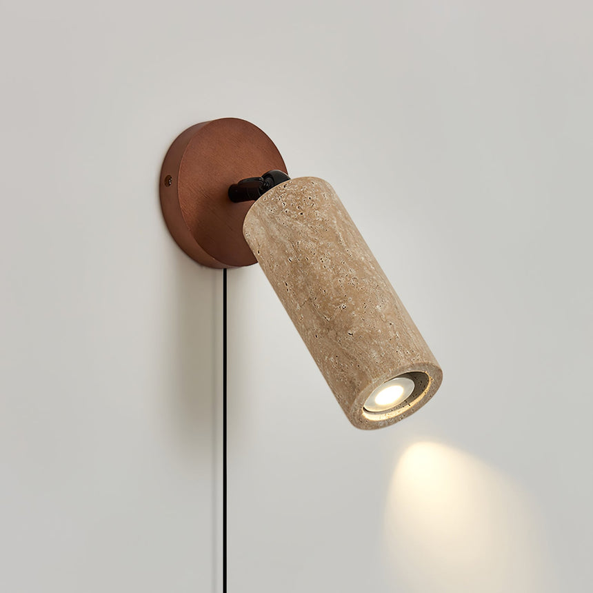The travertine barrel turned down on its joint, a small pool of light below it