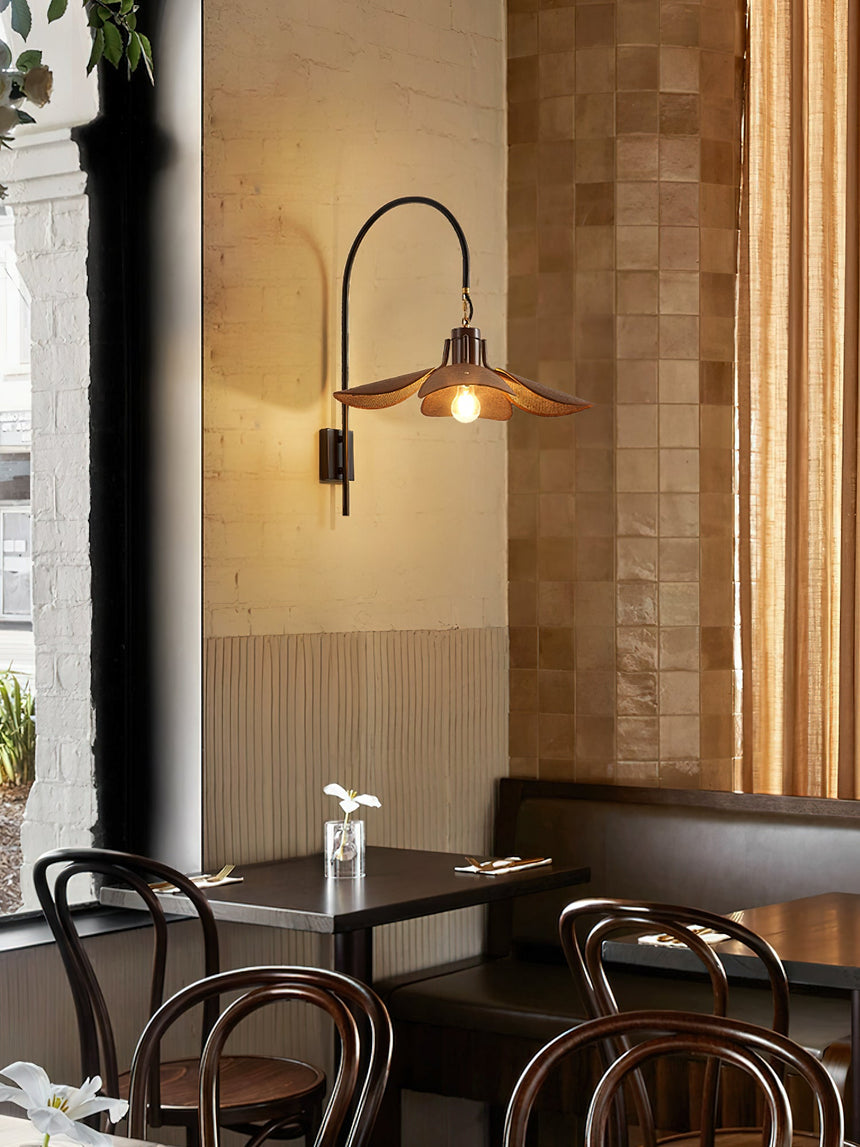 Sconce lit above a marble table with bentwood chairs and a tiled wall