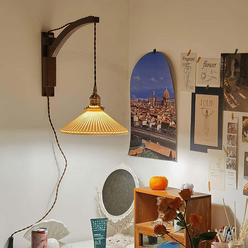 The curved arm version lit above a small vanity table in a bedroom