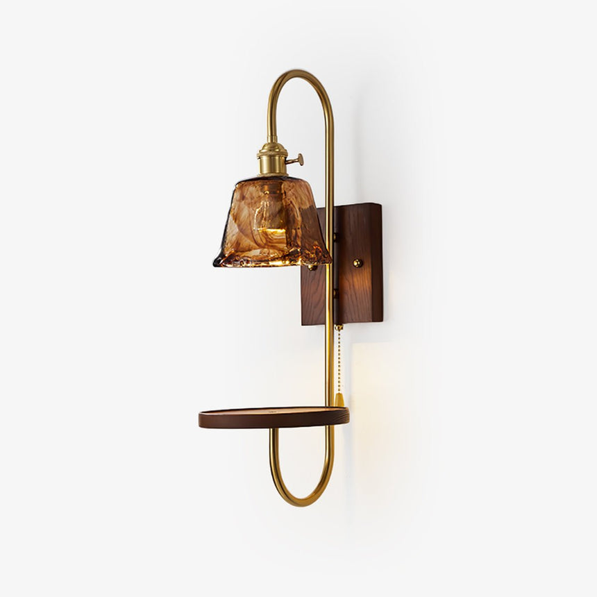 Walnut wall sconce with a shelf and an amber glass shade on a brass arm
