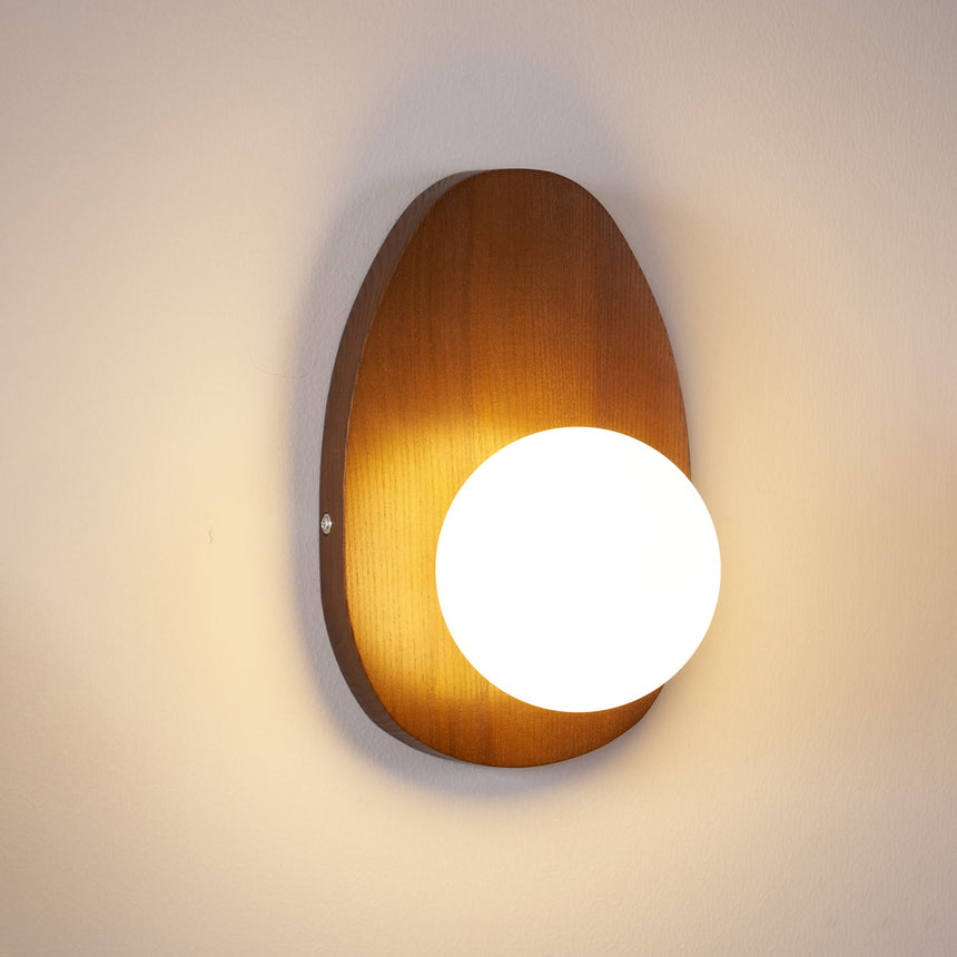 The teardrop plate lit warm, the globe glowing against the walnut grain