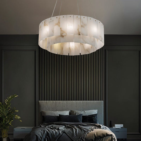 The lit drum in a bedroom above a bed with a paneled wall and a plant