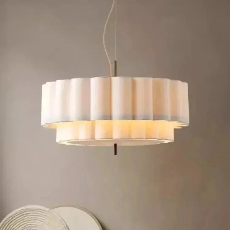 Two tier white drum pendant light seen straight on against a beige wall