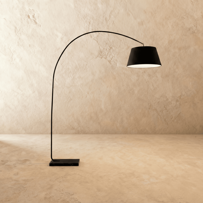 The same curved arm with a black fabric drum shade above a dark stone base