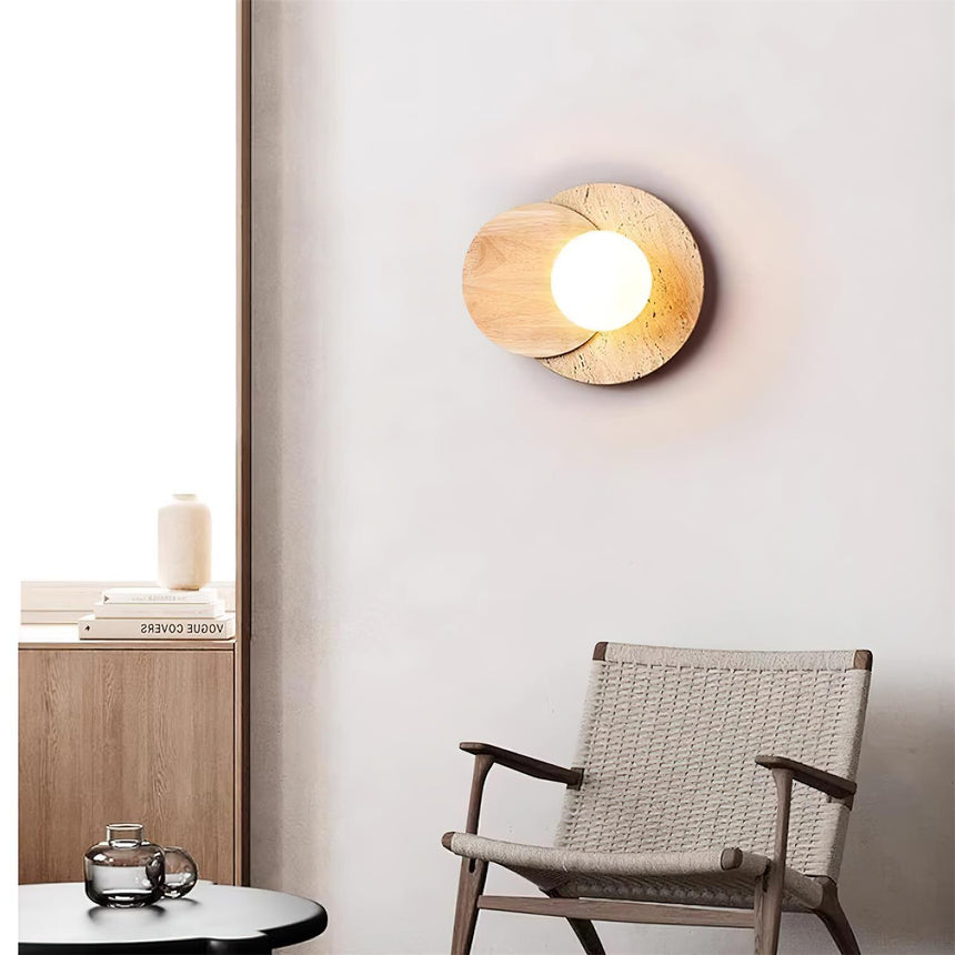 Plug in sconce lit above a round marble table beside a woven chair