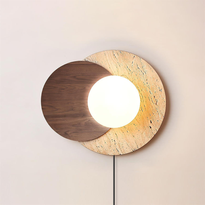 Glass orb lit between a walnut disc and a travertine disc, cord below
