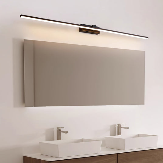 White bar lit above a wide mirror over two basins in a pale bathroom