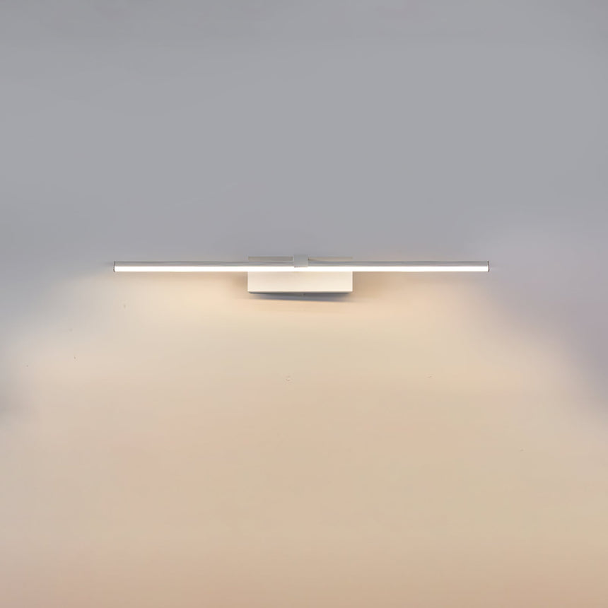 The short white bar lit on a gray wall, the glow pooling under the fitting