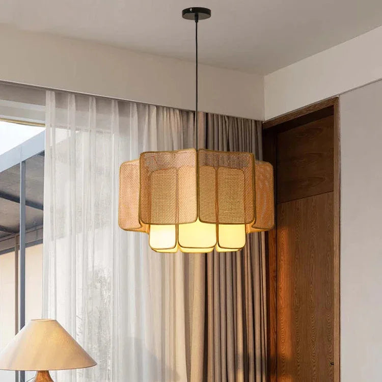 Natural wicker hanging lamp lit in front of a sheer curtain